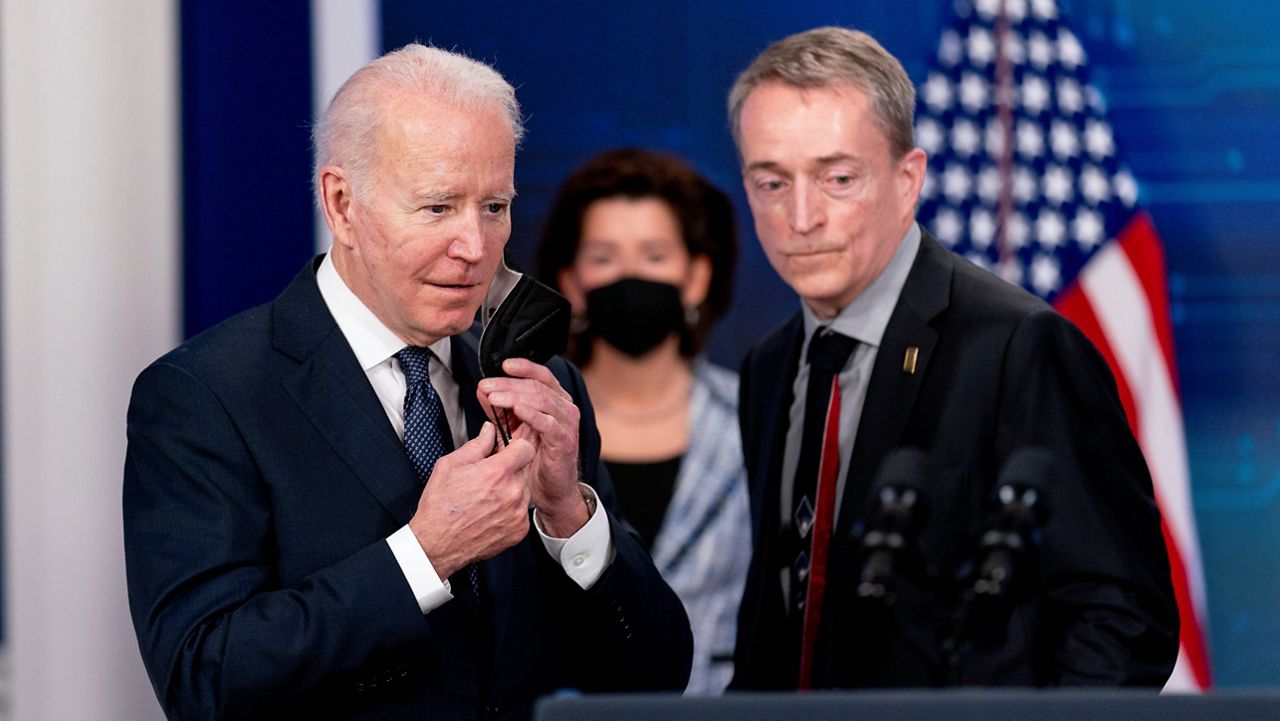 President Joe Biden takes the podium from Intel CEO Patrick Gelsinger on Friday at the South Court Auditorium in the Eisenhower Executive Office Building on the White House campus. (AP Photo/Andrew Harnik)