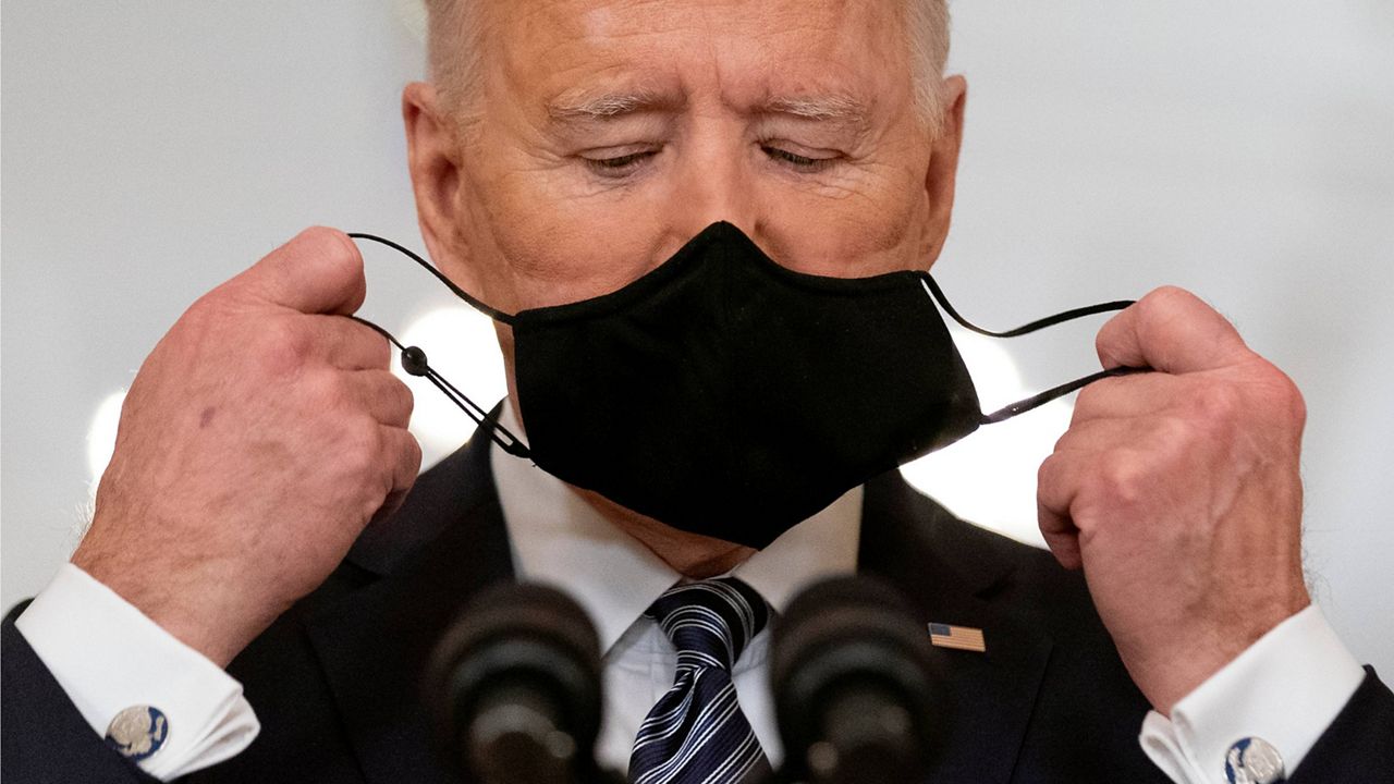 President Joe Biden takes off his mask during a prime-time address from the East Room of the White House on March 11, 2021. (AP Photo/Andrew Harnik, File)