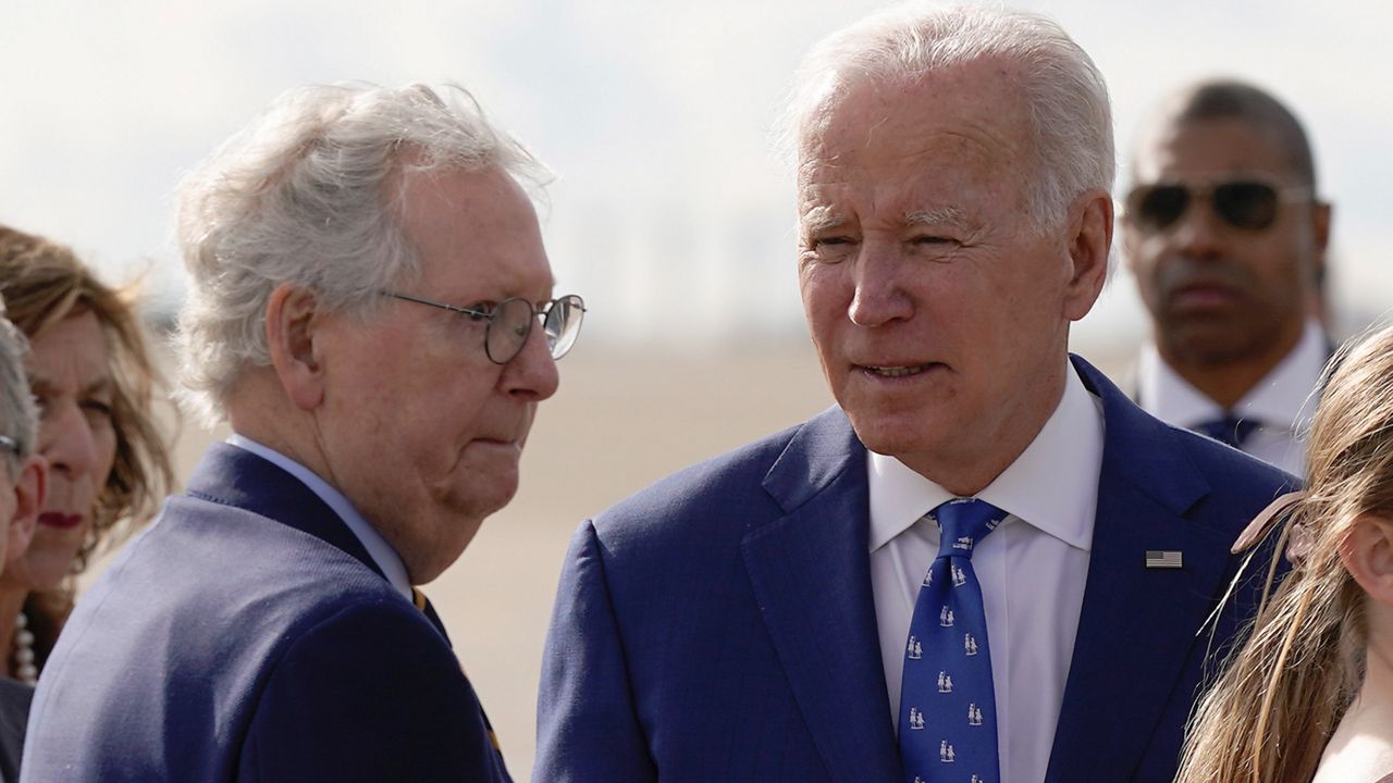 Senate Minority Leader Mitch McConnell of Ky., looks to President Joe Biden after Biden arrived at Cincinnati/Northern Kentucky International Airport in Hebron, Ky., Wednesday, Jan. 4, 2023. (AP Photo/Patrick Semansky)