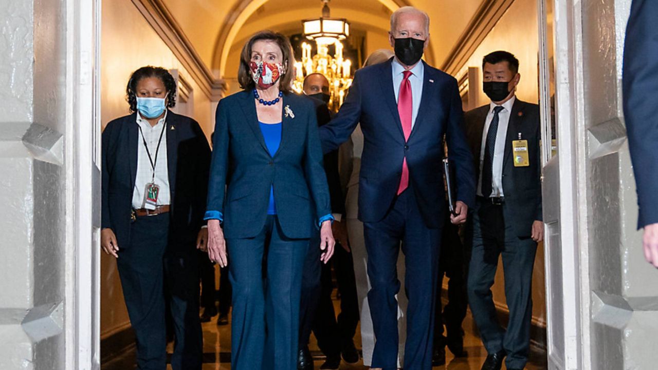 President Joe Biden, right, walks with U.S. House Speaker Nancy Pelosi, left, as talks continue on the White House's massive social policy and environmental bill. (Photo by AP.)