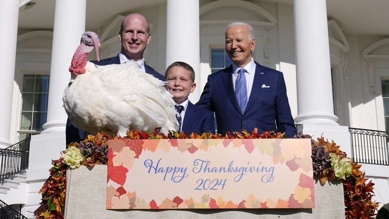 President Joe Biden, right, stands with John Zimmerman, left, chair of the National Turkey Federation, his son Grant Zimmerman, center, and the national Thanksgiving turkey, Peach, during a pardoning ceremony on the South Lawn of the White House in Washington, Monday, Nov. 25, 2024. (AP Photo/Susan Walsh)