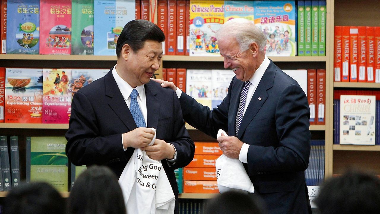 Xi Jinping and Joe Biden — both vice presidents at the time — hold T-shirts students gave them at the International Studies Learning Center in South Gate, Calif., on Feb. 17, 2012. (AP Photo/Damian Dovarganes, File)
