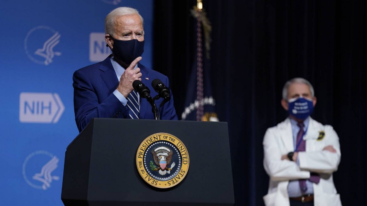 President Joe Biden speaks during a visit to the National Institutes of Health, Thursday, Feb. 11, 2021, in Bethesda, Md. Dr. Anthony Fauci, director of the National Institute of Allergy and Infectious Diseases, listens at right. (AP Photo/Evan Vucci)