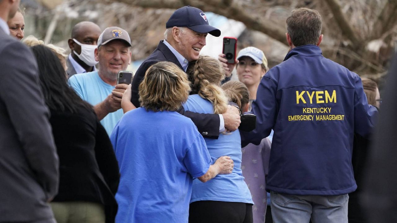 President Joe Biden hugs a person as he surveys storm damage from tornadoes and extreme weather in Dawson Springs, Ky., Wednesday, Dec. 15, 2021. (AP Photo/Andrew Harnik)