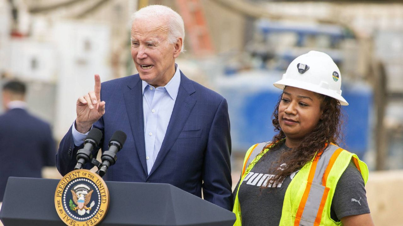 President Joe Biden holds hands with Yurvina Hernandez, right, a union laborer, as he speaks about infrastructure investments at the LA Metro, D Line (Purple) Extension Transit Project - Section 3, in Los Angeles, Thursday, Oct. 13, 2022. (AP Photo/Alex Gallardo)