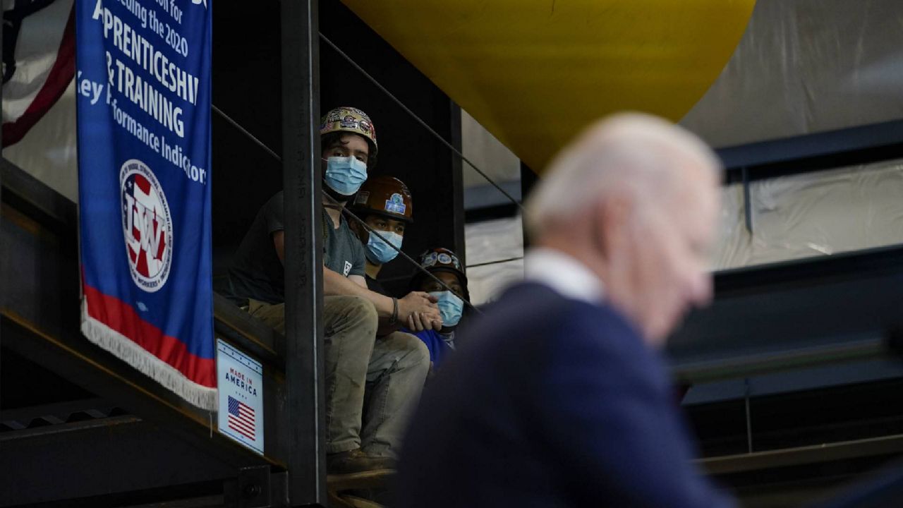 People listen as President Joe Biden speaks before signing an executive order on project labor agreements at the Ironworkers Local 5 in Upper Marlboro, Md., Friday, Feb. 4, 2022. (AP Photo/Carolyn Kaster)