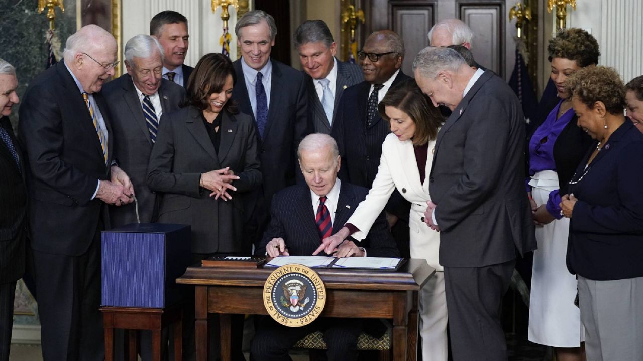 House Speaker Nancy Pelosi of Calif. points to the Consolidated Appropriations Act for Fiscal Year 2022 before President Joe Biden signs the act in the Indian Treaty Room in the Eisenhower Executive Office Building on the White House Campus in Washington, Tuesday, March 15, 2022. (AP Photo/Patrick Semansky)