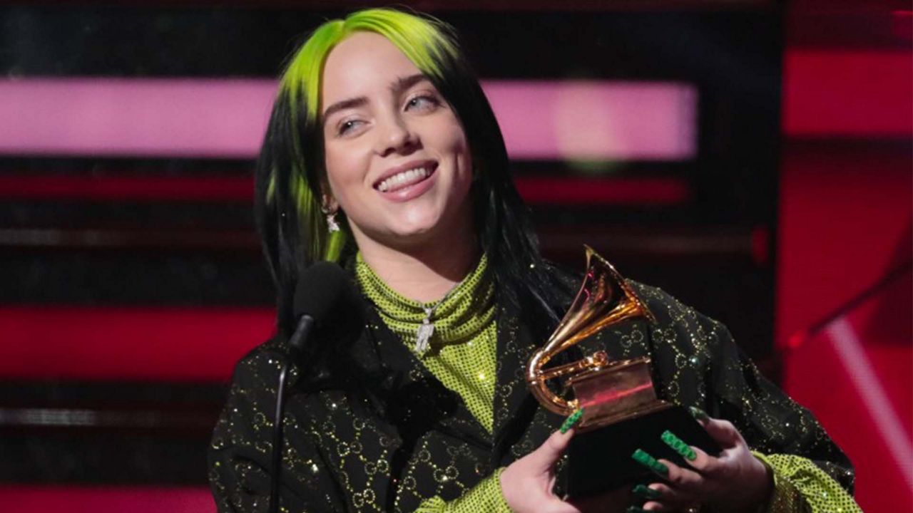 Billie Eilish holding a Grammy award