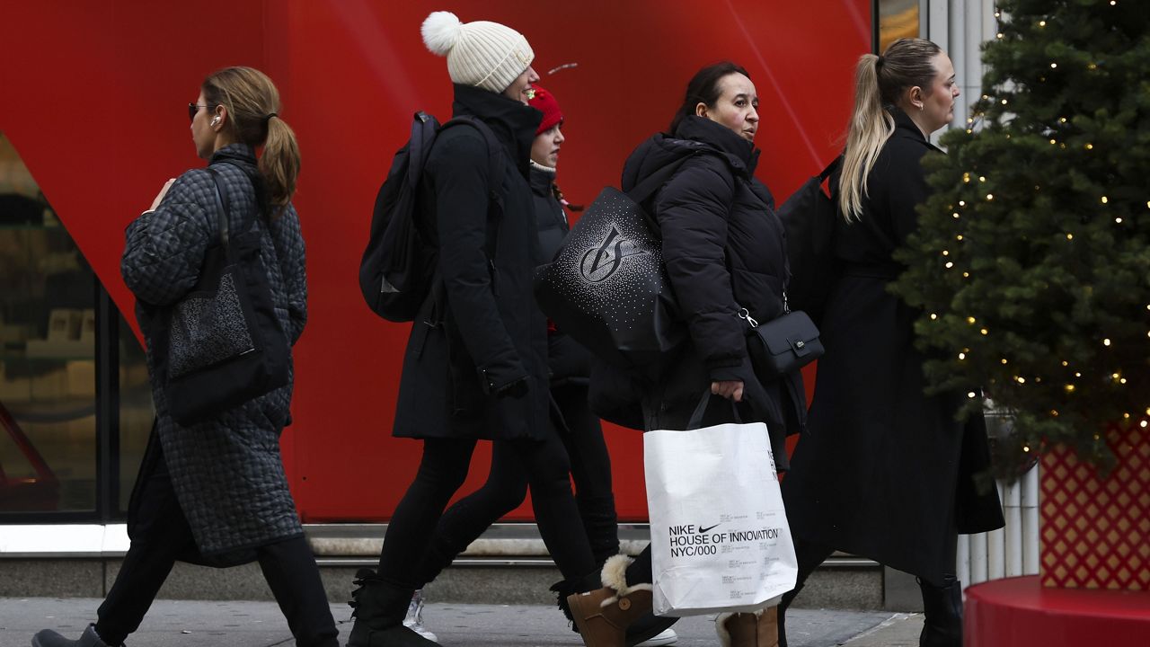 Shoppers walk along Fifth Avenue, Friday, Nov. 29, 2024, in New York. (AP Photo/Heather Khalifa)