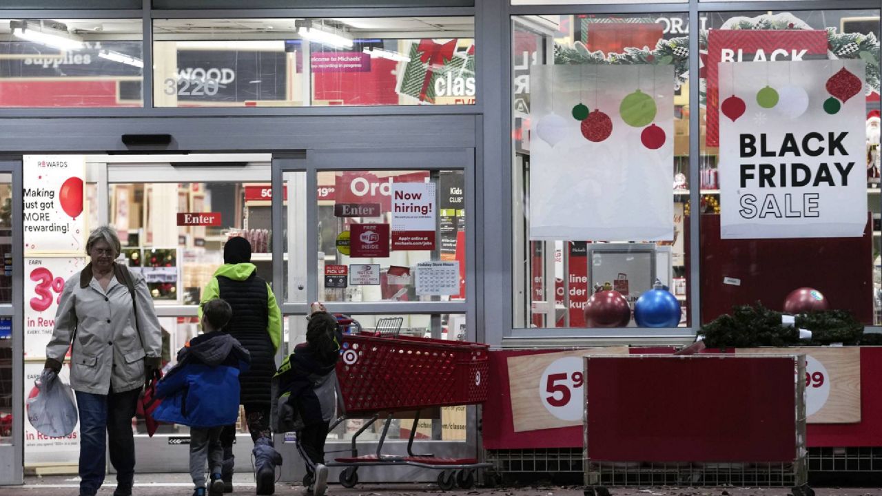 Shoppers are shown where a Black Friday sale sign is posted at a Michaels store in Dearborn, Mich., Monday, Nov. 21, 2022. After last year's holiday season of skimpy discounts, American are seeing price cuts across the board for the holiday period that started a few days earlier in October than last year. (AP Photo/Paul Sancya)