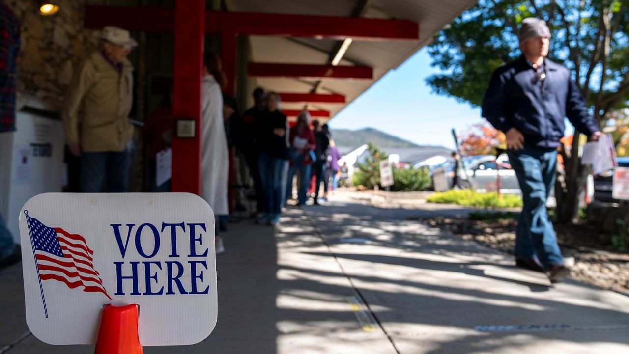 People wait in line at the polling place at Black Mountain Library on the first day of early in-person voting, on Oct. 17, 2024, in Black Mountain, N.C. (AP Photo/Stephanie Scarbrough)