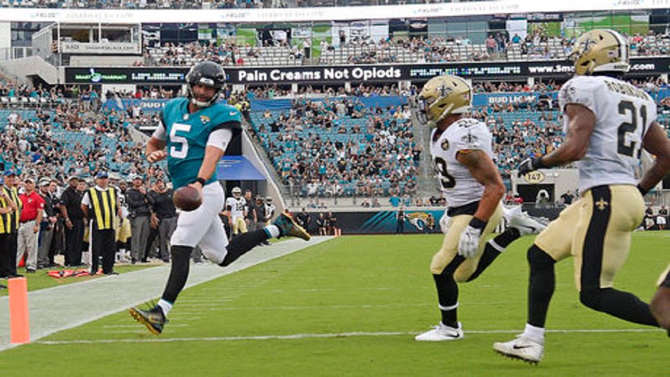 Jacksonville Jaguars quarterback Blake Bortles (5) runs past New Orleans Saints defensive backs Kurt Coleman, center, and Patrick Robinson (21) for a touchdown during the first half of an NFL preseason football game, Thursday, Aug. 9, 2018, in Jacksonville, Fla. (AP Photo/Phelan M. Ebenhack)