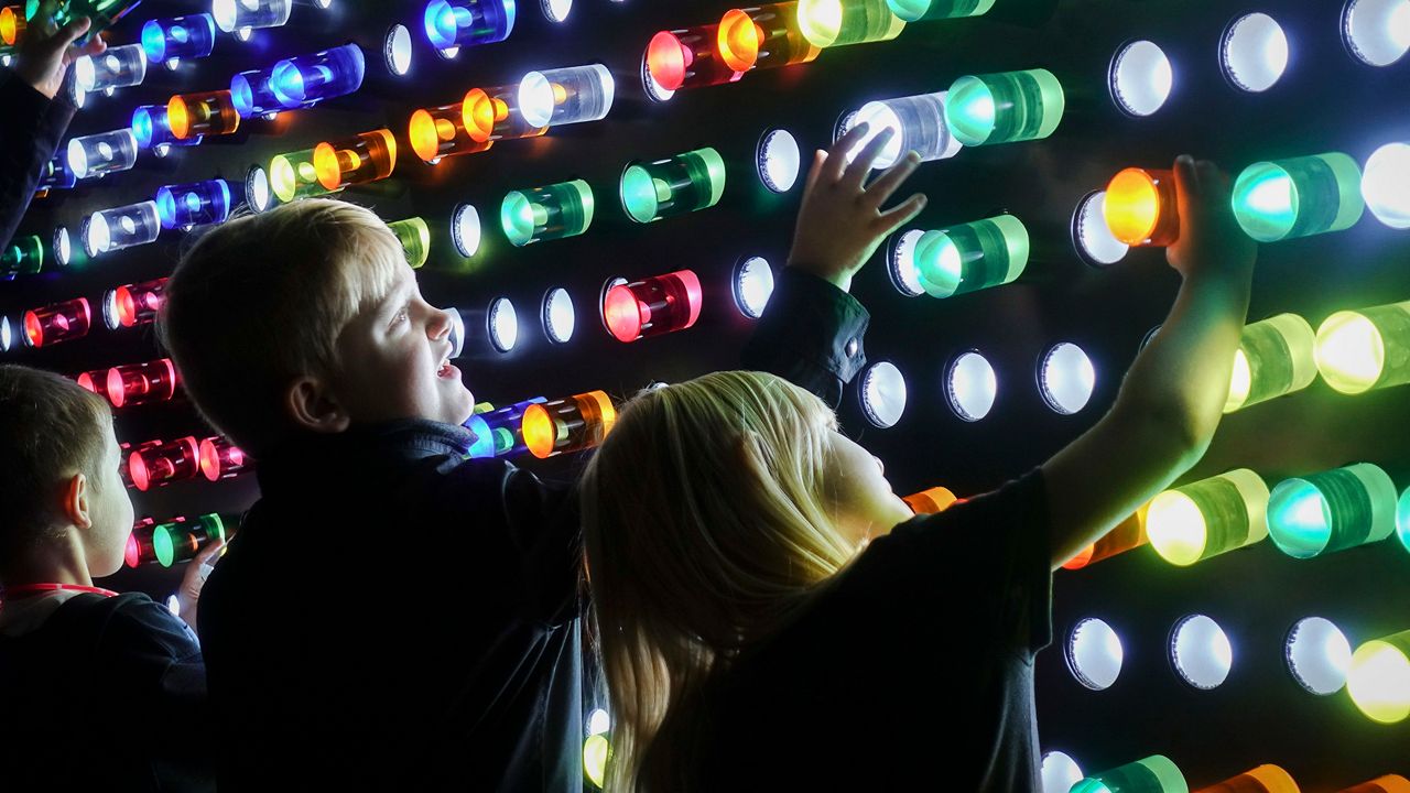 Children interact with a LED pegboard display during the Blink Festival, Thursday, Oct. 12, 2017, in Cincinnati. (AP Photo/John Minchillo)