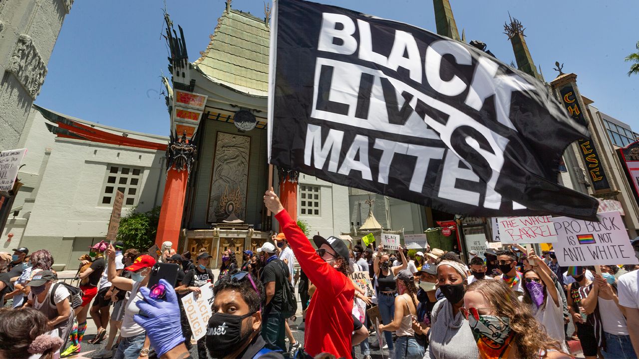 Thousands of people march past the TCL Chinese Theatre on Hollywood Boulevard for an "All Black Lives Matter" march organized by black members of the LGBTQ+ community in the Hollywood section of Los Angeles Sunday, June 14, 2020. (AP Photo/Damian Dovarganes)