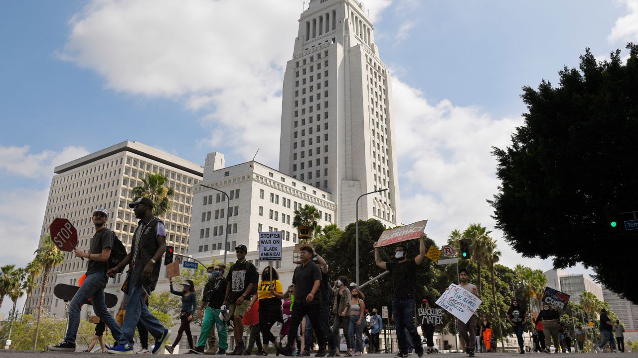 Demonstrators walk past Los Angeles City Hall during a Black Lives Matter protest, Wednesday, June 17, 2020, at the Hall of Justice in Los Angeles. Protesters are asking for the removal of Los Angeles District Attorney Jackie Lacey. (AP Photo/Mark J. Terrill)