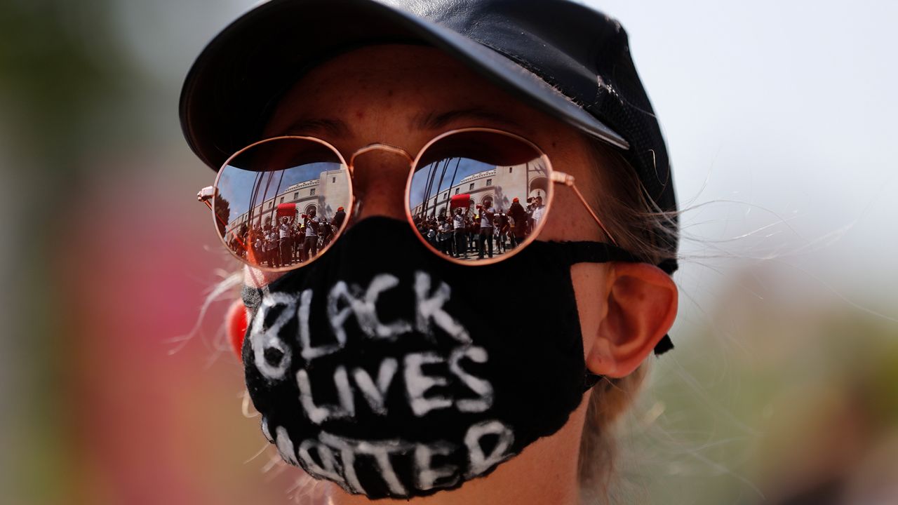 Demonstrators are reflected on the sunglasses of a woman during a protest Thursday, June 4, 2020, in Los Angeles, over the death of George Floyd on May 25 in Minneapolis. (AP Photo/Jae C. Hong)