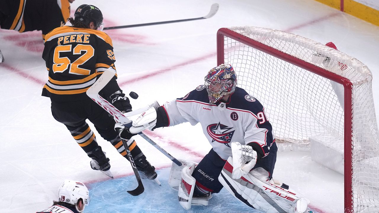 Columbus Blue Jackets goaltender Elvis Merzlikins (90) makes a save against Boston Bruins defenseman Andrew Peeke (52) during the first period of an NHL hockey game, Monday, Nov. 18, 2024, in Boston. (AP Photo/Charles Krupa)