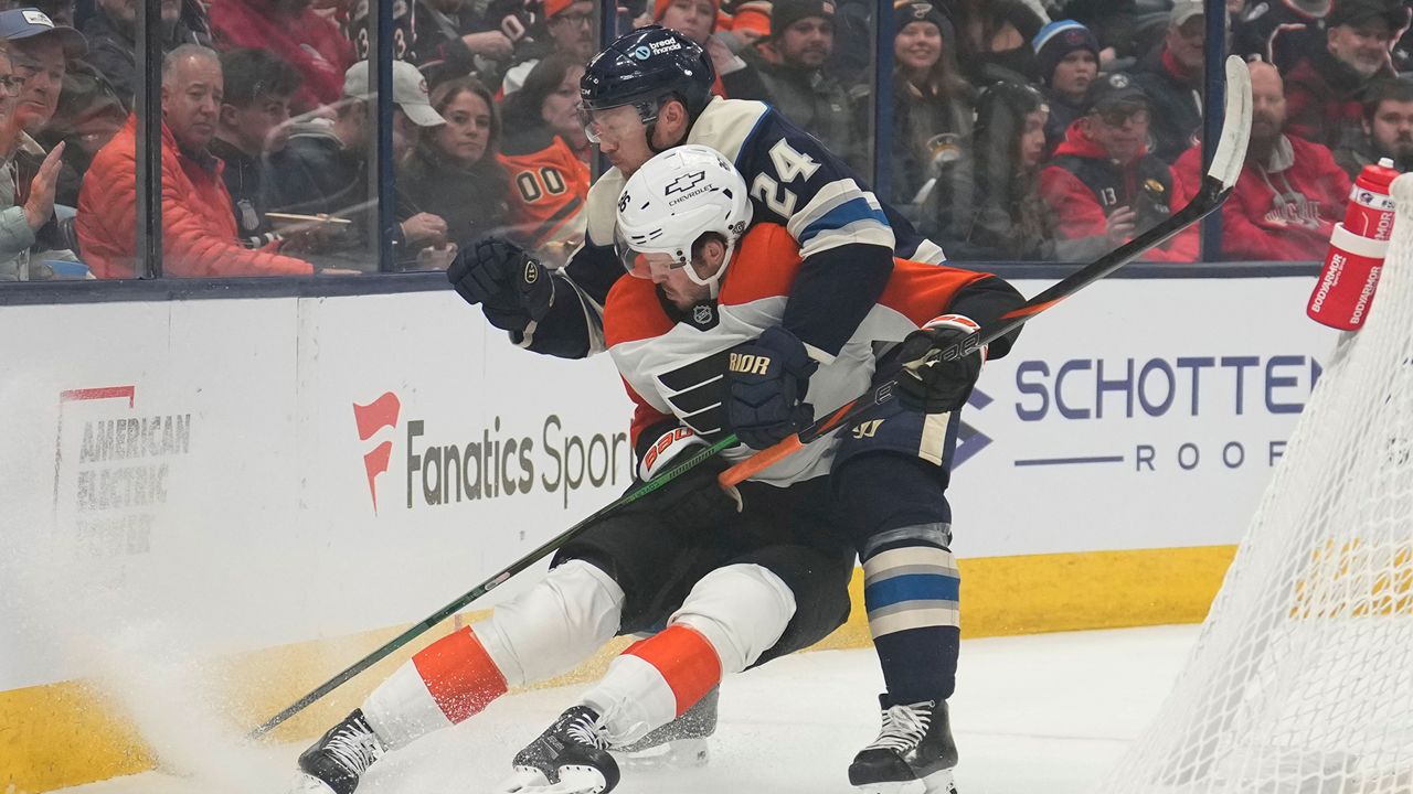 Columbus Blue Jackets right wing Mathieu Olivier (24) and Philadelphia Flyers left wing Joel Farabee, left, fight for control of the puck in the first period of an NHL hockey game Tuesday, Dec. 10, 2024, in Columbus, Ohio. (AP Photo/Sue Ogrocki)