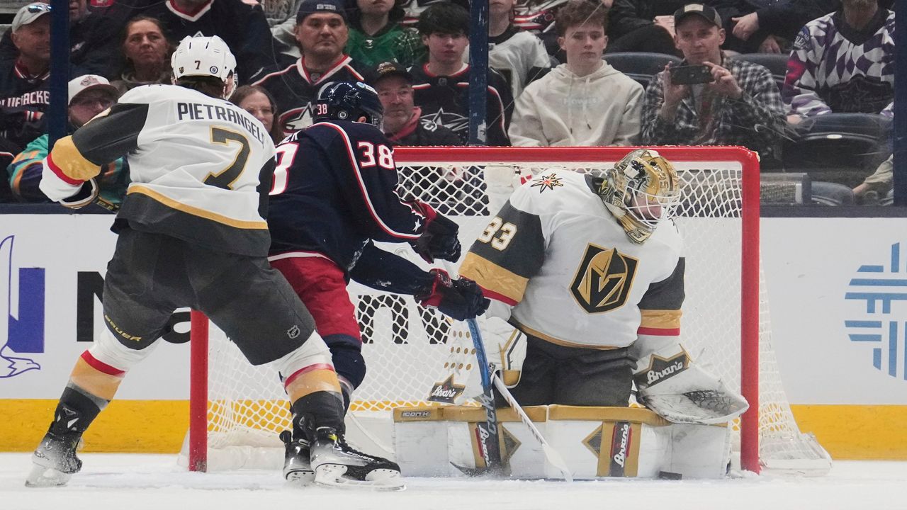 Vegas Golden Knights goaltender Adin Hill (33) blocks a shot by Columbus Blue Jackets center Boone Jenner (38) in the first period of an NHL hockey game Thursday, March 13, 2025, in Columbus, Ohio. (AP Photo/Sue Ogrocki)