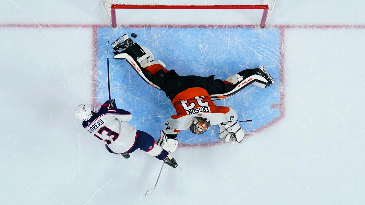 Columbus Blue Jackets' Johnny Gaudreau, left, scores a goal against Philadelphia Flyers' Samuel Ersson during a shootout in an NHL hockey game, Thursday, Jan. 4, 2024, in Philadelphia. (AP Photo/Matt Slocum)