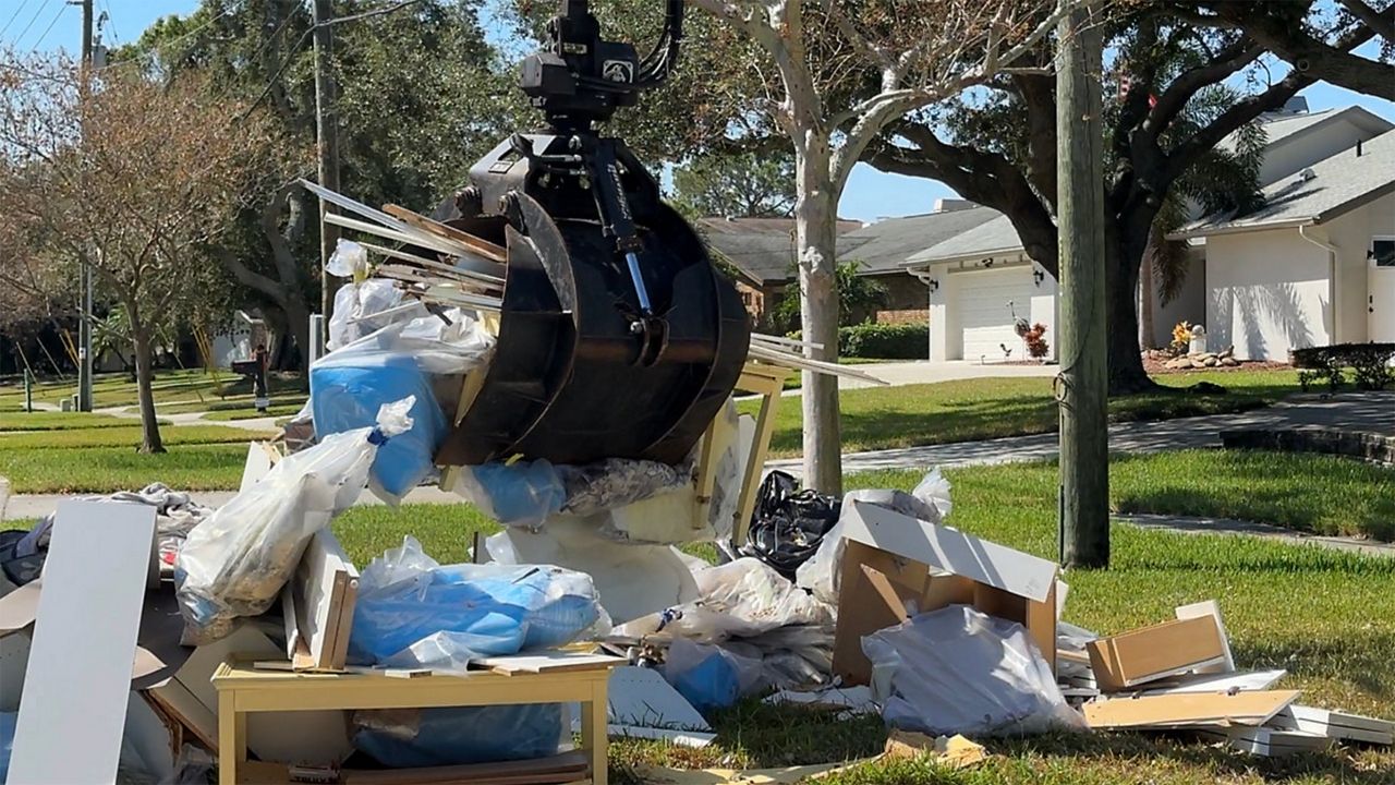 Debris being removed in front of a home in the Shore Acres area of St. Pete. (Spectrum News/Cait McVey)