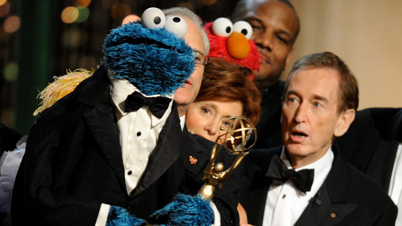 Bob McGrath, right, looks at the Cookie Monster as they accept the Lifetime Achievement Award for '"Sesame Street" at the Daytime Emmy Awards on Aug. 30, 2009, in Los Angeles. (AP Photo/Chris Pizzello)