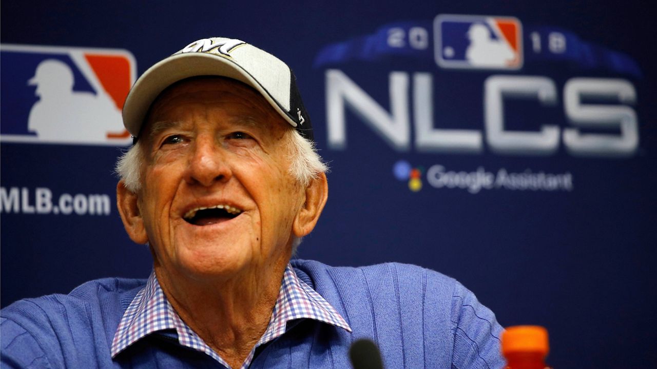 Broadcaster Bob Uecker, right, waves to the crowd after throwing out the ceremonial first pitch before a baseball game between the Milwaukee Brewers and the New York Mets Saturday, Sept. 25, 2021, in Milwaukee. 