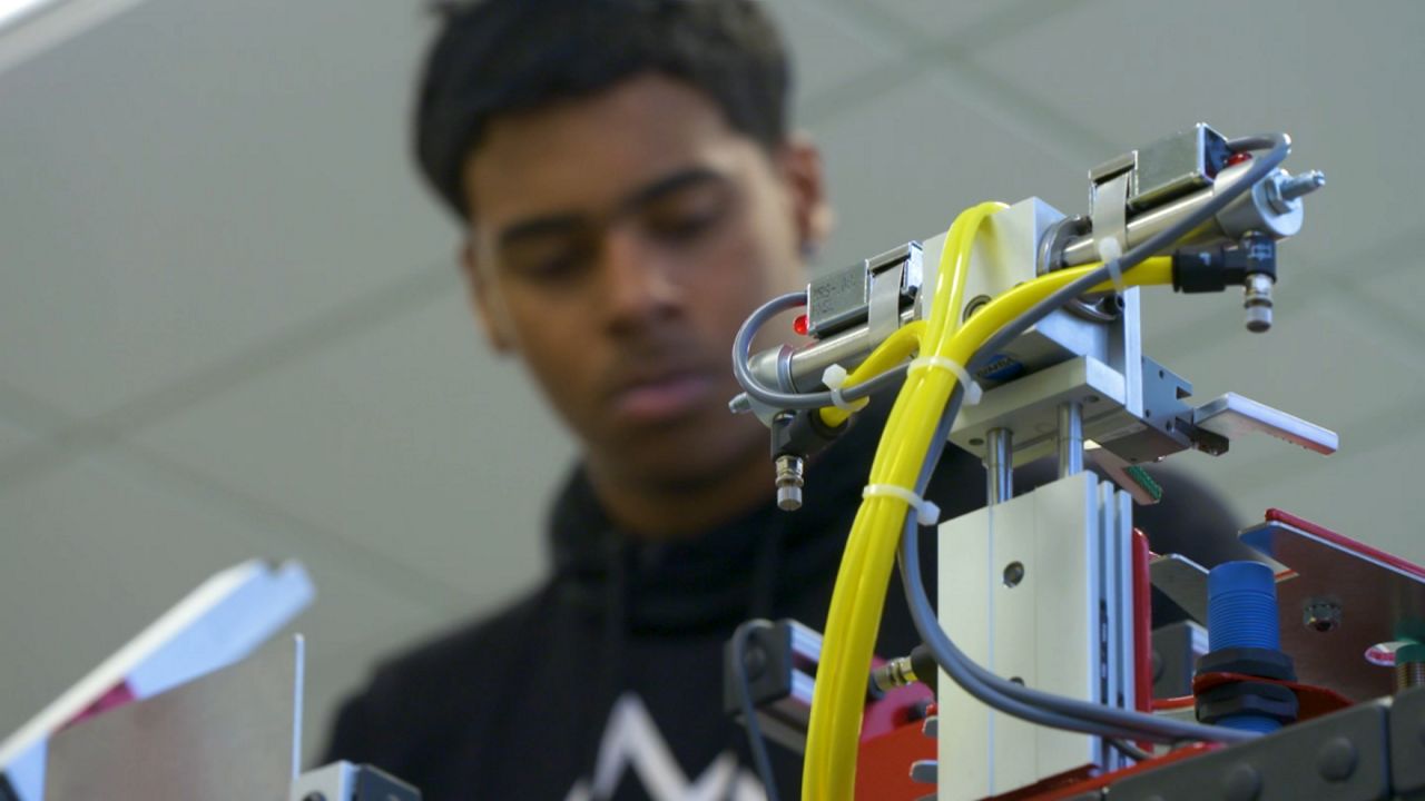 BOCES student works on project with electronic implement in foreground