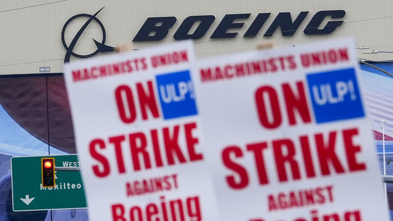 Boeing workers wave picket signs as they strike after union members voted to reject a contract offer, Sunday, Sept. 15, 2024, near the company's factory in Everett, Wash. (AP Photo/Lindsey Wasson, File)