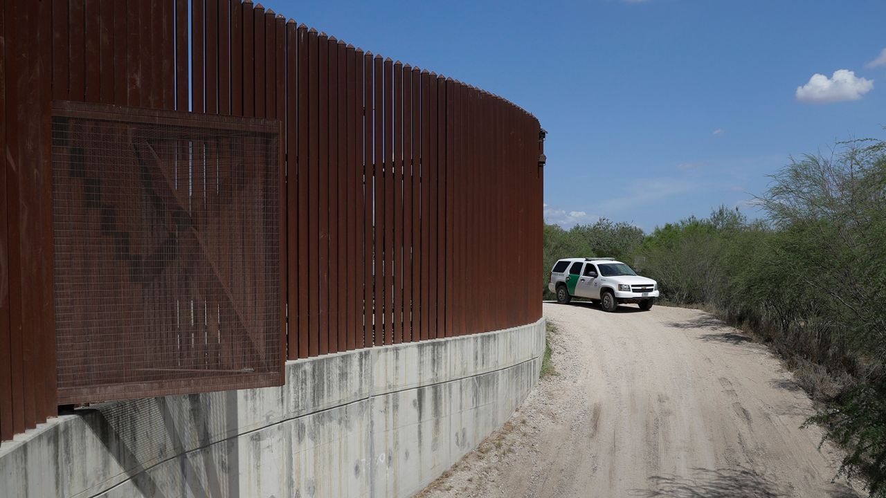 A border patrol vehicle drives along the border wall. (Associated Press)
