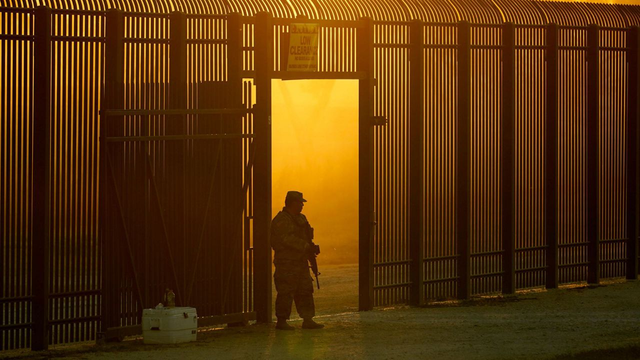 A National Guardsman stands guard at a fence that runs along the Rio Grande near the International bridge, Friday, Sept. 17, 2021, in Del Rio, Texas. (AP Photo/Eric Gay, File)