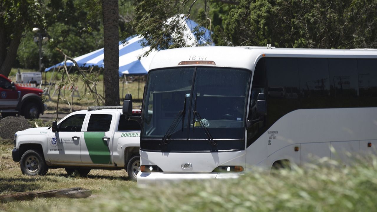 A Border Patrol vehicle and bus are parked near a staging area near the U.S.-Mexico border in Brownsville, Texas, Saturday, April 29, 2023. The city of Brownsville signed a disaster declaration after nearly 15,000 migrants crossed through the area, with many of them screened and released from federal custody into the city. (AP Photo/Valerie Gonzalez)