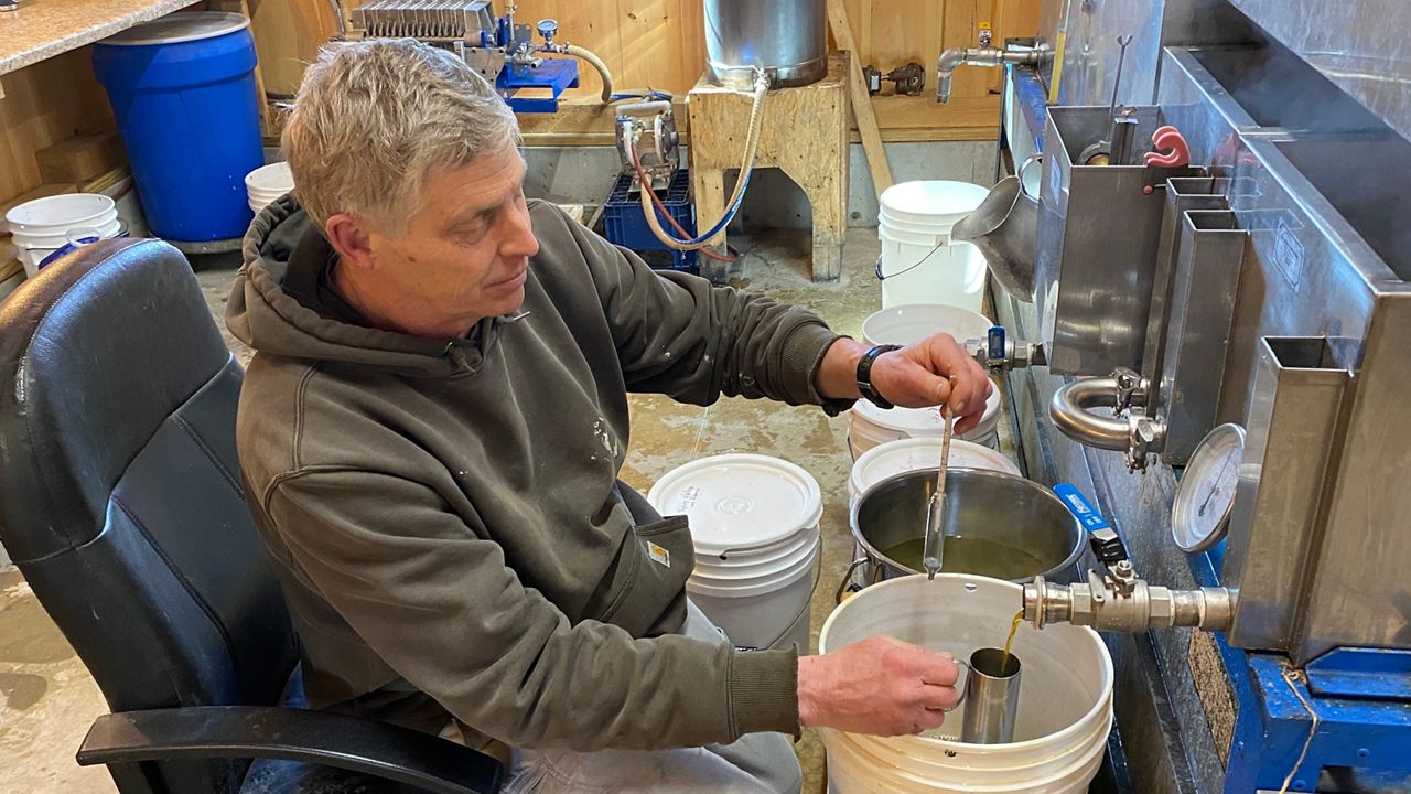Frank Boucher, co-owner of Giles Family Farm in Alfred, checks on the quality of the syrup he is producing from boiling sap in spring 2022. This year, Boucher said despite the mild weather, "could be a record year." (File photo)