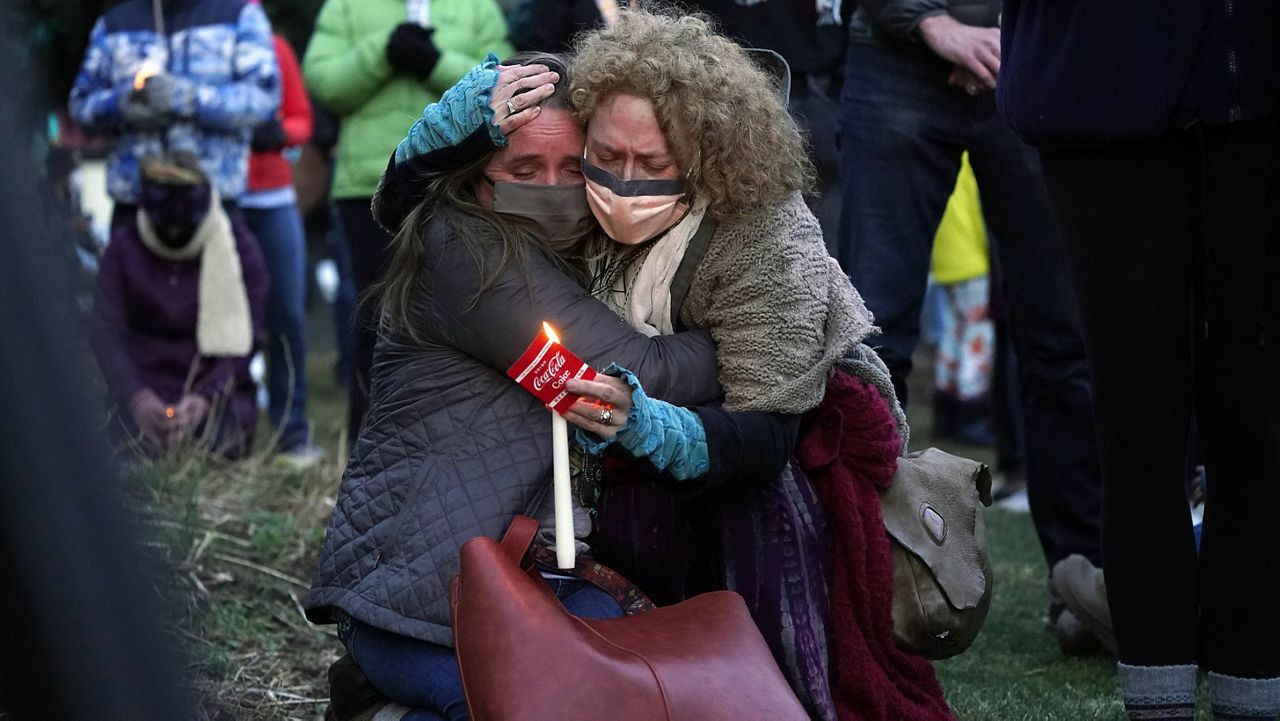 Mourners in Boulder, Colorado, hug at a vigil Wednesday for the victims of the mass shooting at the Kings Sooper supermarket. (AP Photo/David Zalubowski)