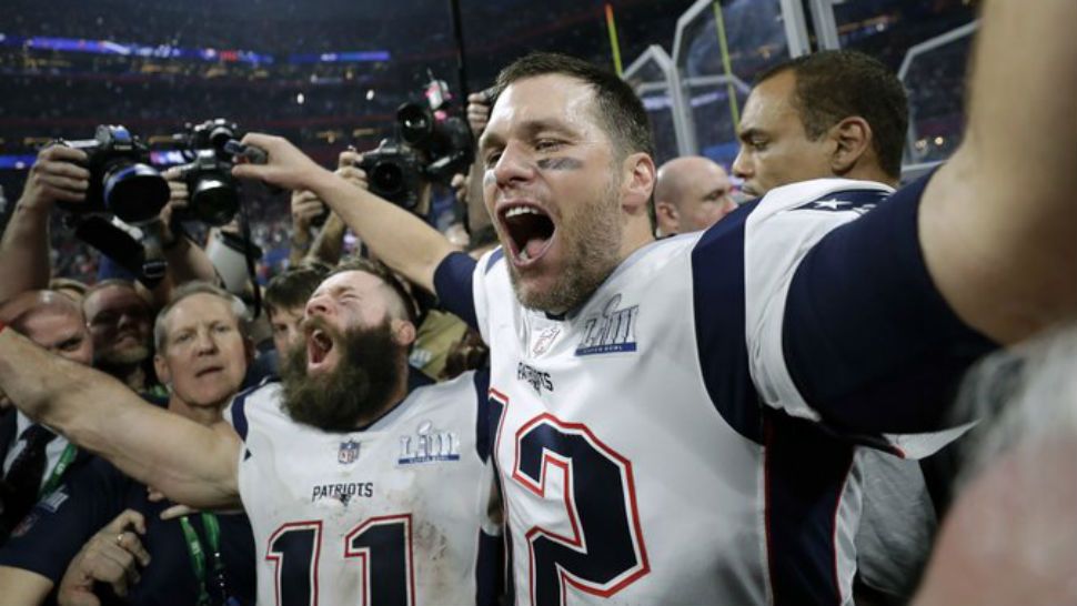 Patriots players Tom Brady and Julian Edelman cheer after their Super Bowl victory Sunday. (Spectrum News)