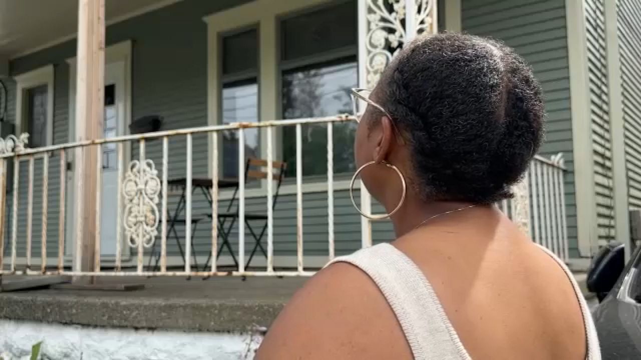 Brandi Barrett looks at her childhood home in Buffalo's Fruit Belt neighborhood. (Spectrum News 1/Brianne Roesser Photo)