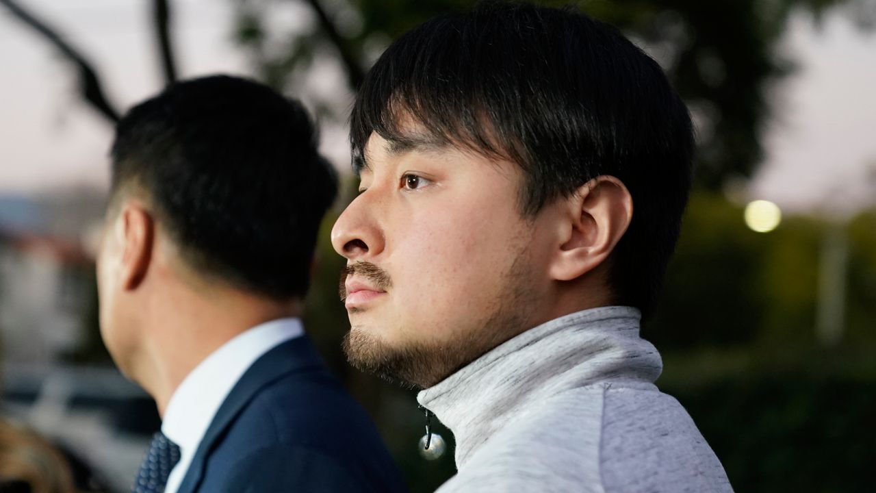 Brandon Tsay, 26, right, and his father, Tom Tsay, make a statement outside their home on Jan. 23, 2023, in San Marino, Calif. (AP Photo/Ashley Landis)