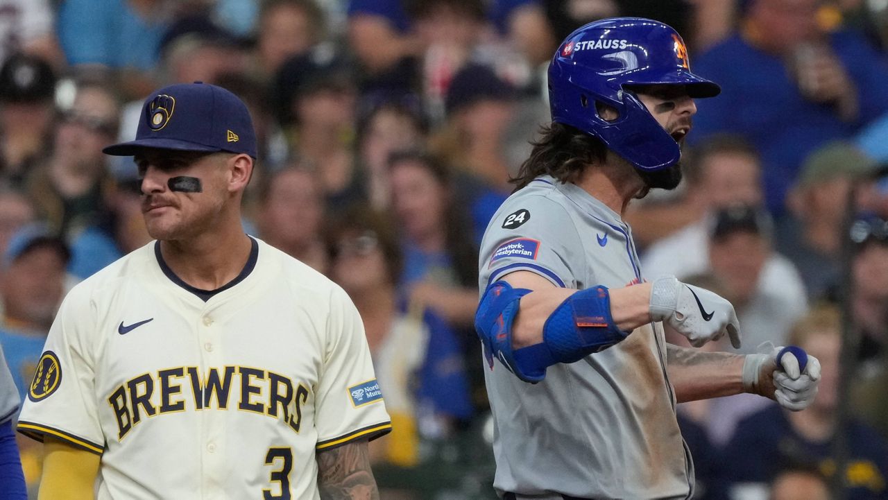 New York Mets' Jesse Winker reacts in front of Milwaukee Brewers third base Joey Ortiz