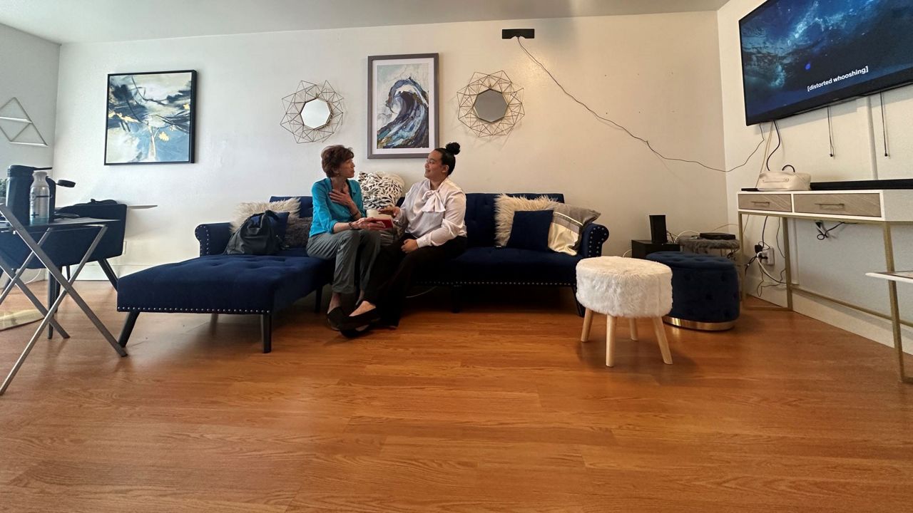 Yasmine Arencibia and Kate Santich of the Homeless Services Network sit at Arencibia's apartment, which is being funded by the Brighter Days Community Initiative. (Spectrum News/Sasha Teman)