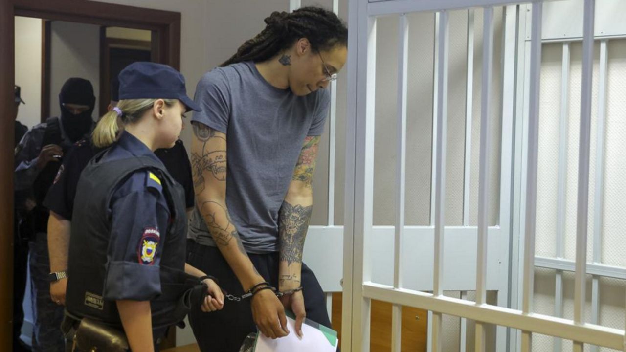 WNBA star and two-time Olympic gold medalist Brittney Griner, right, enters a cage in a courtroom prior to a hearing in Khimki just outside Moscow, Russia, Thursday, Aug. 4, 2022. (Evgenia Novozhenina/Pool Photo via AP)