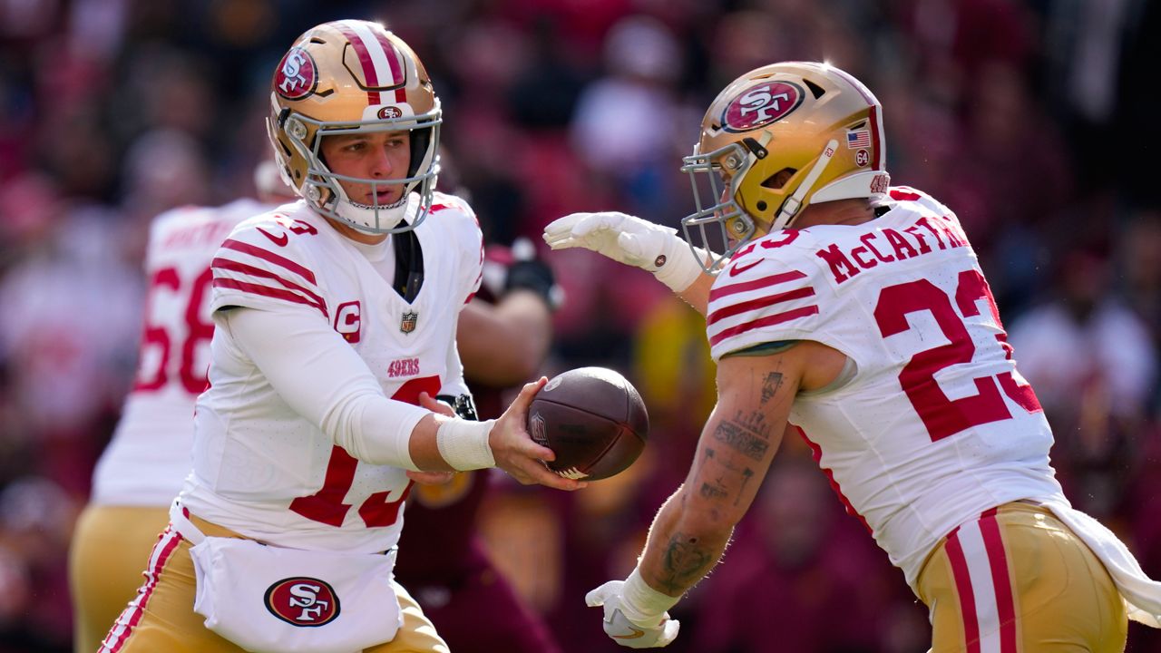 San Francisco 49ers quarterback Brock Purdy (13) hands the ball off to running back Christian McCaffrey (23) during the first half of an NFL football game against the Washington Commanders, Sunday, Dec. 31, 2023, in Landover, Md. 