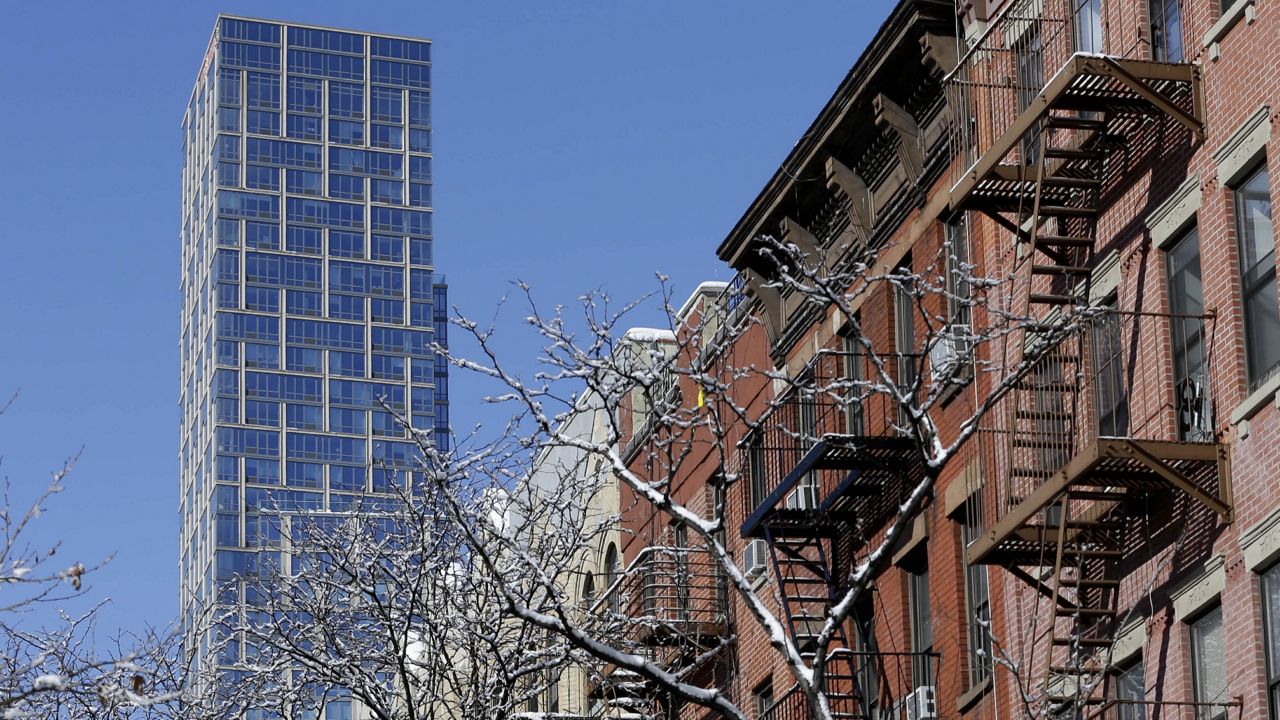 A high rise looms over row houses in East Harlem, in Manhattan. (AP Photo/Seth Wenig)