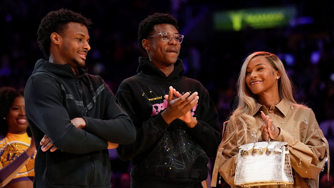 From left, Bronny James, Bryce James, and Savannah James applaud during a ceremony honoring Los Angeles Lakers forward LeBron James as the NBA's all-time leading scorer before an NBA game against the Milwaukee Bucks on Thursday, Feb. 9, 2023, in Los Angeles. (AP Photo/Mark J. Terrill)