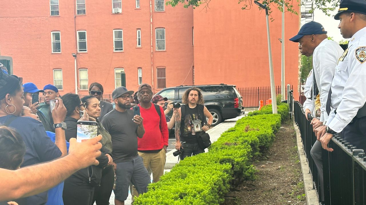 Parents stopped Mayor Eric Adams at the scene, calling for change. (Spectrum News NY1/Louis Finley)