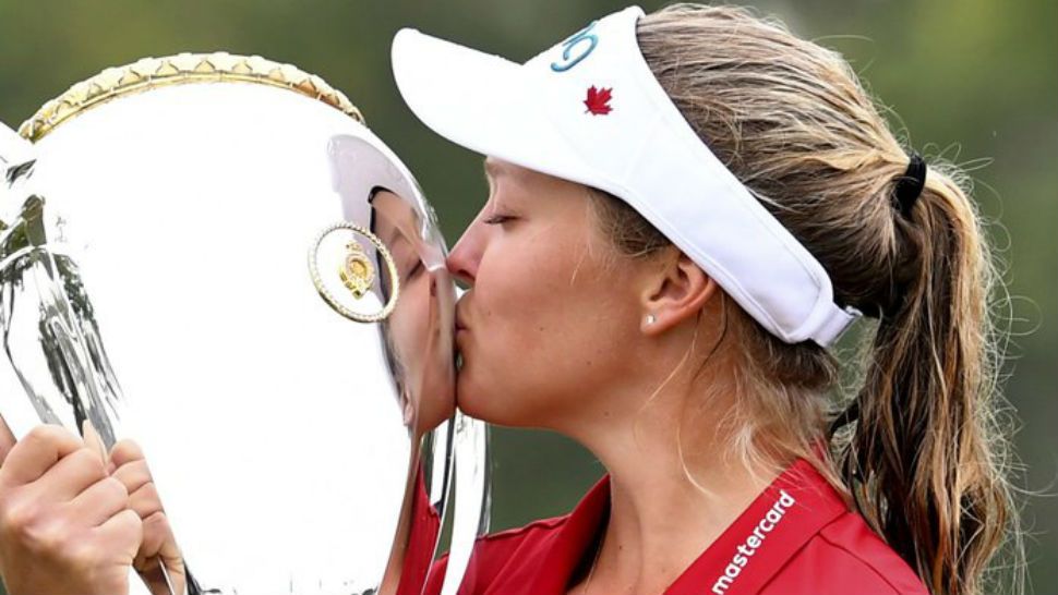 Canada’s Brooke Henderson kisses the trophy as she celebrates her win at the Women’s Canadian Open golf tournament in Regina, Saskatchewan, Sunday Aug. 26, 2018. (Jonathan Hayward/The Canadian Press via AP)
