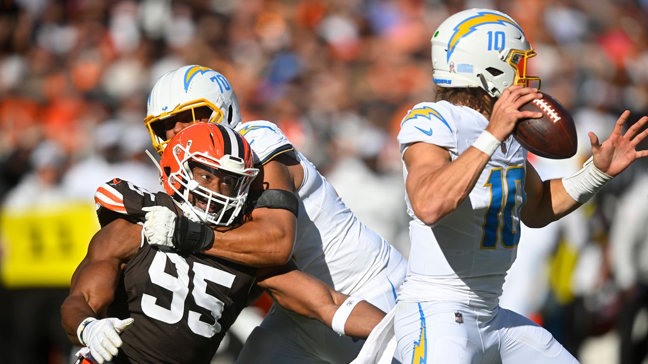 Los Angeles Chargers offensive tackle Rashawn Slater (70) keeps Cleveland Browns defensive end Myles Garrett (95) away from Chargers' quarterback Justin Herbert (10) in the first half of an NFL football game Sunday, Nov. 3, 2024, in Cleveland. (AP Photo/David Richard)