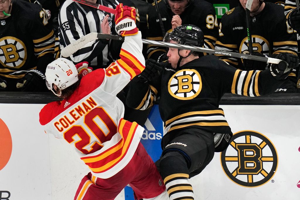 Calgary Flames center Blake Coleman (20) checks Boston Bruins center Charlie Coyle, right, during the second period of an NHL hockey game, Tuesday, Feb. 6, 2024, in Boston. (AP Photo/Charles Krupa)