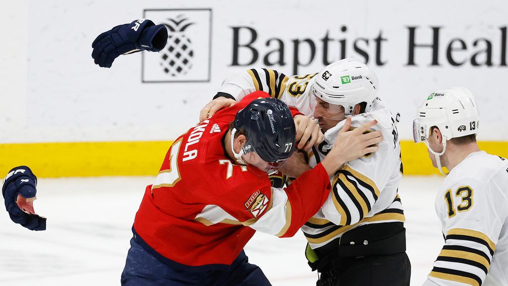 Boston Bruins center Charlie Coyle (13) watches teammate left wing Brad Marchand (63) and Florida Panthers defenseman Niko Mikkola (77) fight during the second period of an NHL hockey game, Tuesday, March 26, 2024, in Sunrise, Fla. (AP Photo/Rhona Wise)