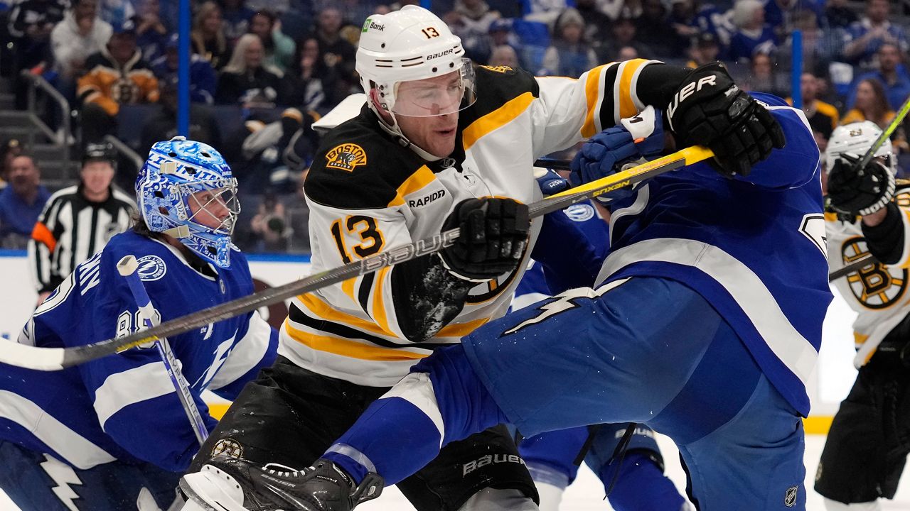 Boston Bruins center Charlie Coyle (13) battles with Tampa Bay Lightning right wing Mitchell Chaffee during the third period of an NHL hockey game Thursday, Jan. 9, 2025, in Tampa, Fla. (AP Photo/Chris O'Meara)