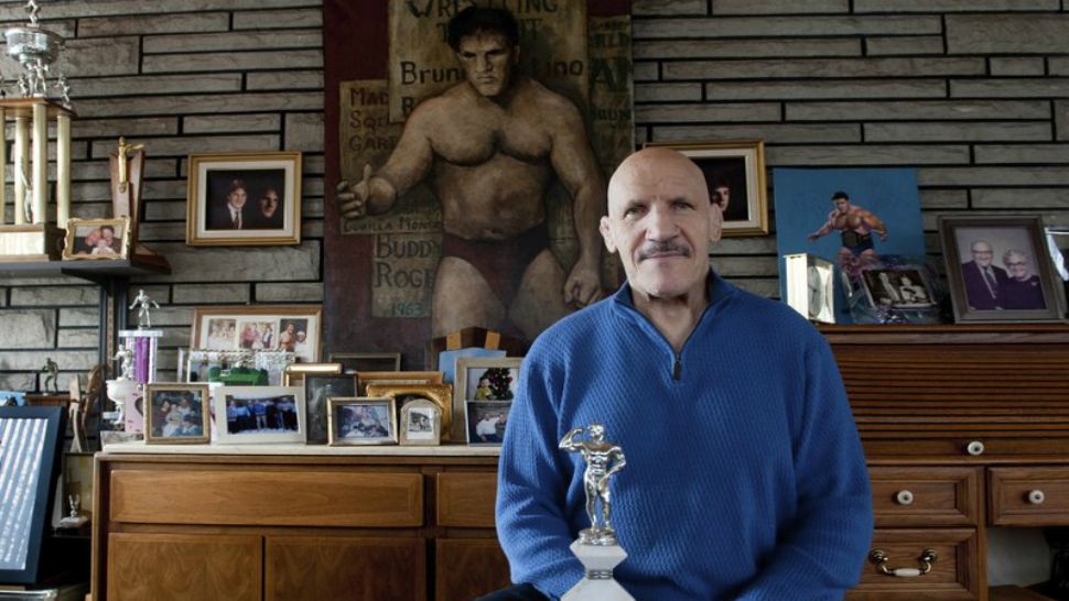 In this March 27, 2013, file photo, Bruno Sammartino sits in front of pictures, paintings and trophies highlighting his storied career as a wrestler and weightlifter, at his home in North Hill, Pa. (Andrew Russell/Pittsburgh Tribune-Review via AP, File)